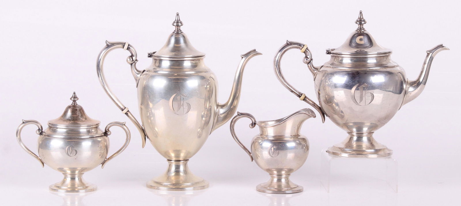 A Four Piece Sterling Silver Tea Set: A coffeepot, teapot, covered sugar and creamer. Dimensions:From 5" x 3 1/2" to 10" x 5", the heights range from 5" to 11". The total approximate weight is 62 troy ounces. Provenance: