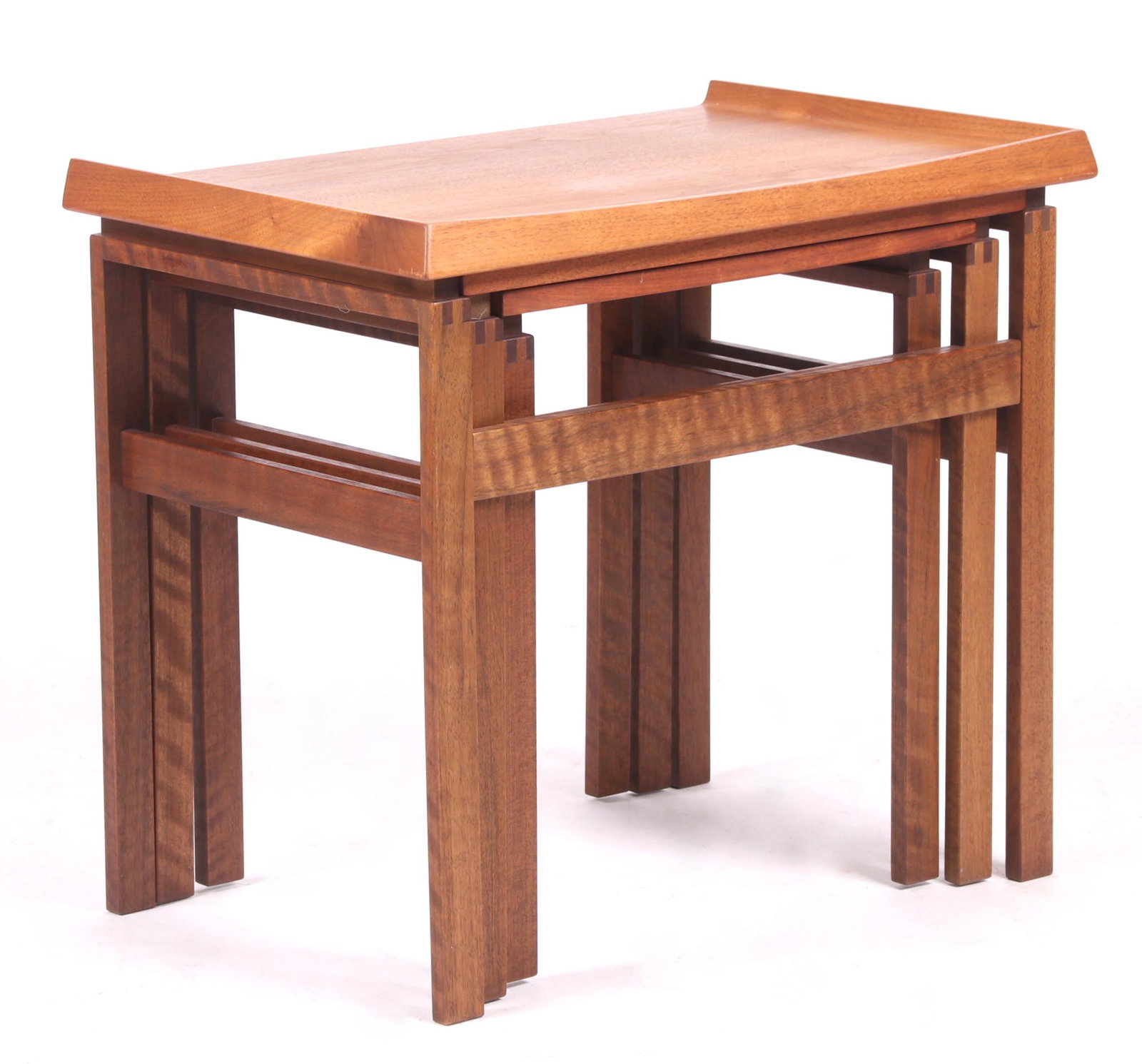 A Set of Three Teak Nesting Tables: Scandinavian. Each with a tray top and square legs. Dimensions:Tops range from 16" x 13 1/2" to 23" x 14 1/2". Heights range from 18" to 20". Provenance:From a local estate.