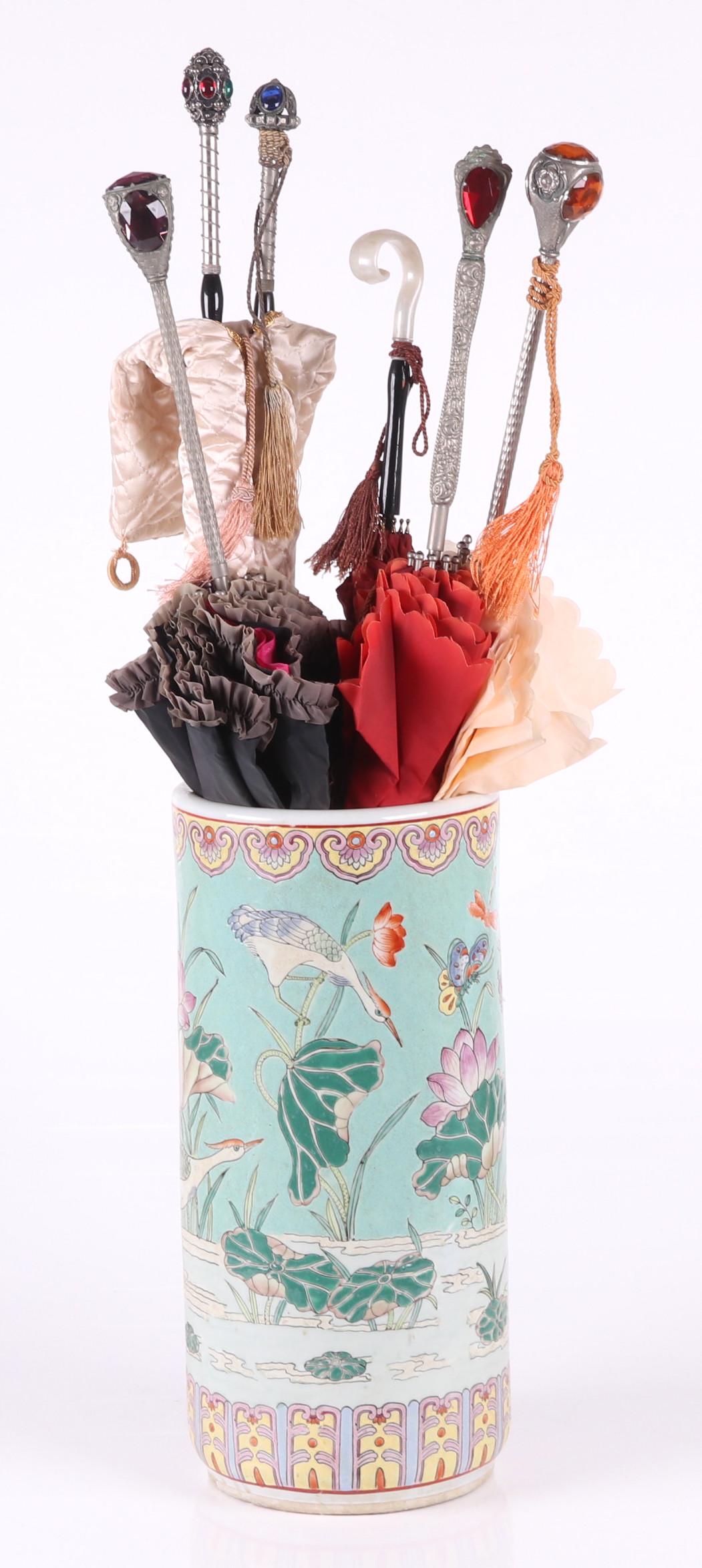 A Chinese Umbrella Stand, Parasols: A 20th century Chinese porcelain umbrella stand with bird and lotus decoration and six vintage parasols, one by Nailon. Five with glass "jewels" and silver tone handle. Dimensions:The stand is 8 1/4" 