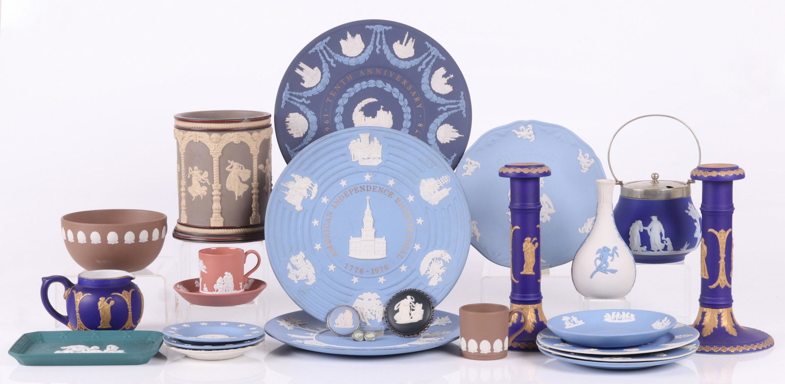A Large Group of Jasperware Including Wedgwood: 19th and 20th centuries, comprising: a blue and gold Dudson creamer, a matching pair of candlesticks, a 1978 Christmas plate, a brown and cream colored jar (unmarked, no lid), a Wedgwood jam pot with 