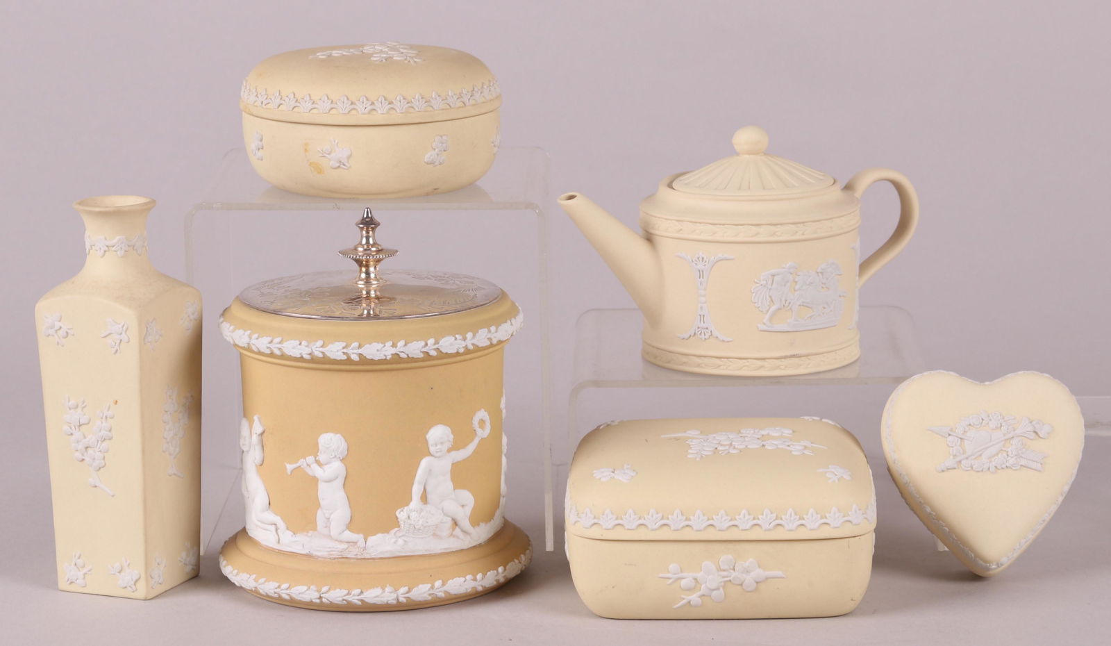 A Group of Wedgwood Yellow Jasperware: Comprising: A jasper dip jar with silver plated lid which appears to be original, three solid jasper boxes, a small drum form teapot and a bud vase. Dimensions:From 3" x 2 3/4" to 5 1/2" x 3", the hei