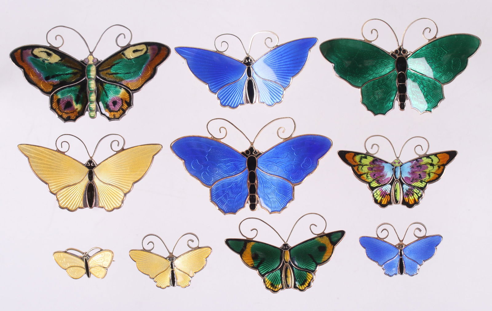 Ten Sterling, Enamel Butterfly Pins, David Andersen: Norway, ten pins, various sizes and colors as pictured. Each marked for the maker and sterling. Dimensions:From 7/8" x 3/8" to 2 1/4" x 1 1/2". The total approximate weight is 3 troy ounces. Provenanc