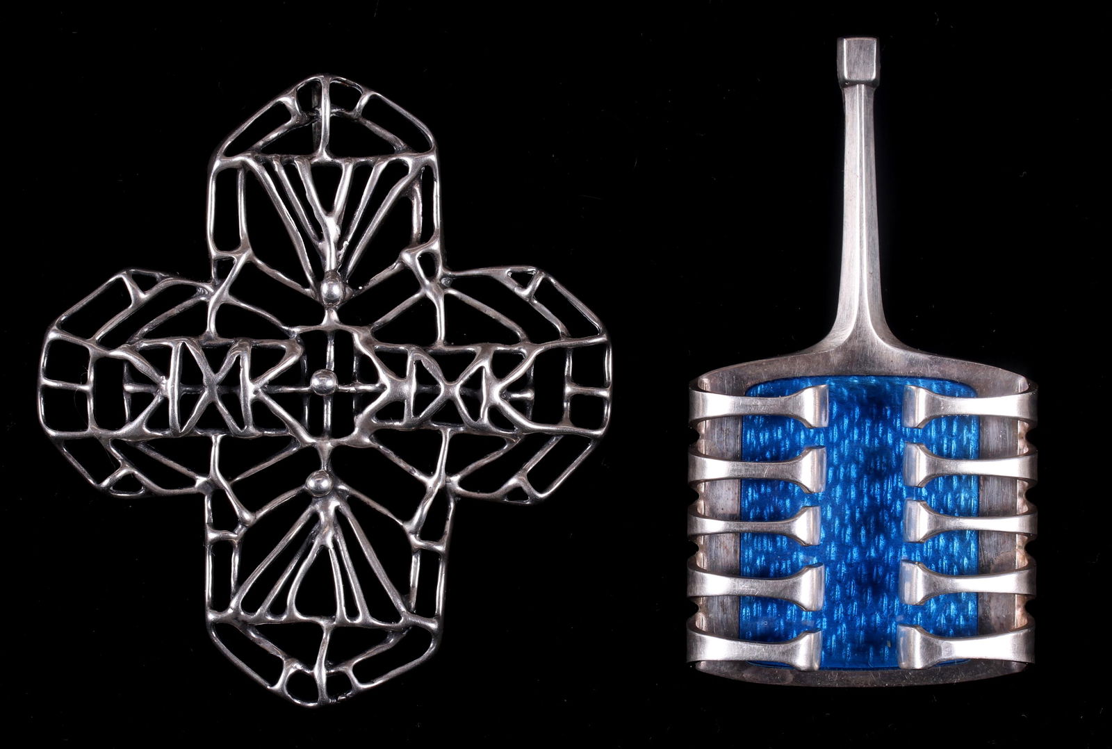 Two Modernist Pendants By David Andersen: Both sterling silver and marked, one with blue enamel, the other is openwork and cross form. Dimensions:The blue example is 2 1/2" x 1 3/8", the other is 2 1/2" x 2 1/2", the total approximate gross w