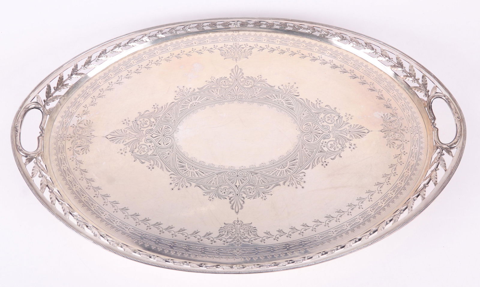 A Large Sterling Silver Tray, Frederick Elkington: Hallmarked for Frederick Elkington, London and the year 1877. Oval with a pierced foliated edge and elaborately engraved surface. Dimensions:25" x 17", 1 1/2" tall. The approximate weight is 110 troy