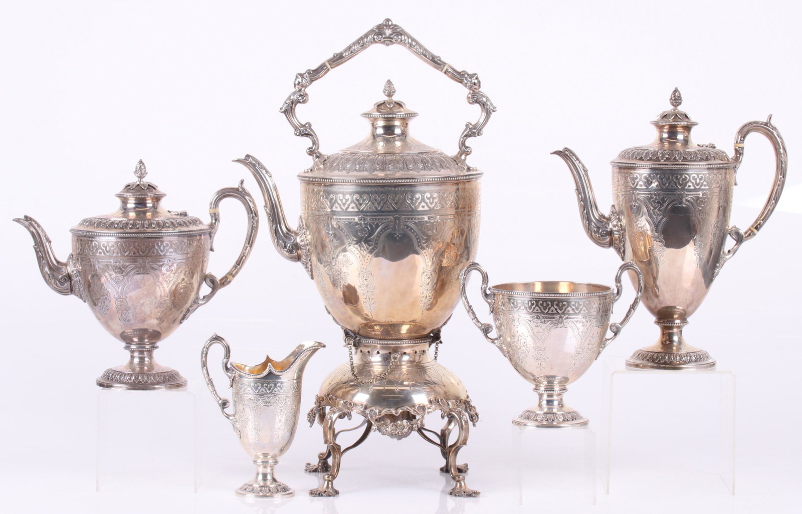 An English Sterling Tea Service, 19th Century: A kettle and stand hallmarked for James William Benson, Sheffield and the year 1884. The coffee pot and teapot bear hallmarked for Richard Martin & Ebenezer Hall and the year 1882, the open sugar and 