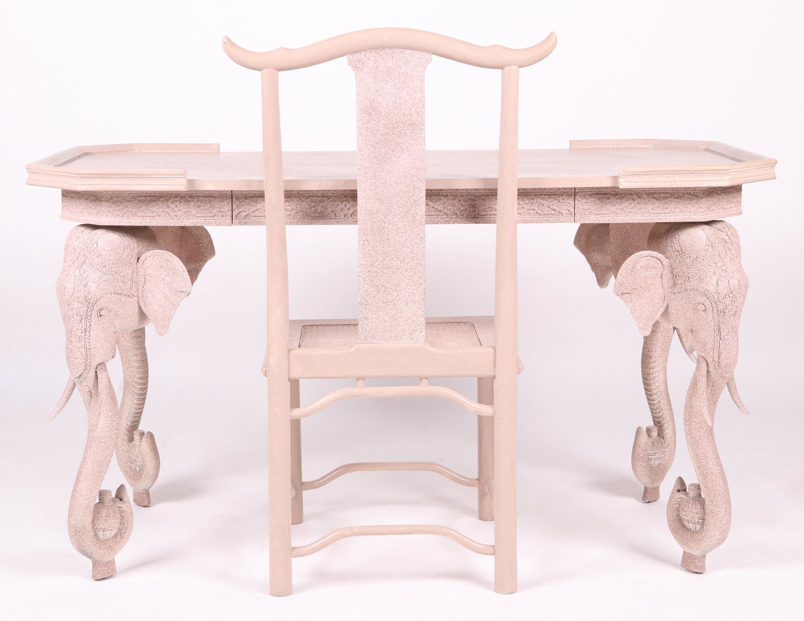 A Modern Elephant Decorated Desk and Chair: In the Anglo Indian style with elephant head legs and a single long drawer. The top with canted corners and partial molding. The matching chair features a caned seat and a yoke style crestrail. Dimens