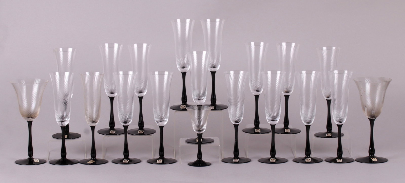 A Group of Crystal Stemware by Sasaki: In the "Royale" pattern, each with a black foot and stem and a twist decorated bowl. Nearly all retain the original paper label. Comprising: seventeen 9" flutes, two 8" wine glasses and one 5 3/4" she