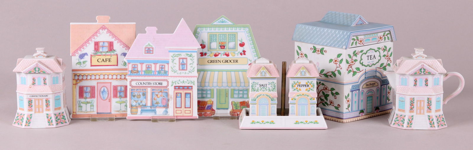 A Group of Lenox Porcelain "Village" Pieces: Three trivets, a creamer and sugar set, a shaker set and a canister. Dimensions: From 2" x 2" to 5" x 5", the heights range from 1/2" to 5".