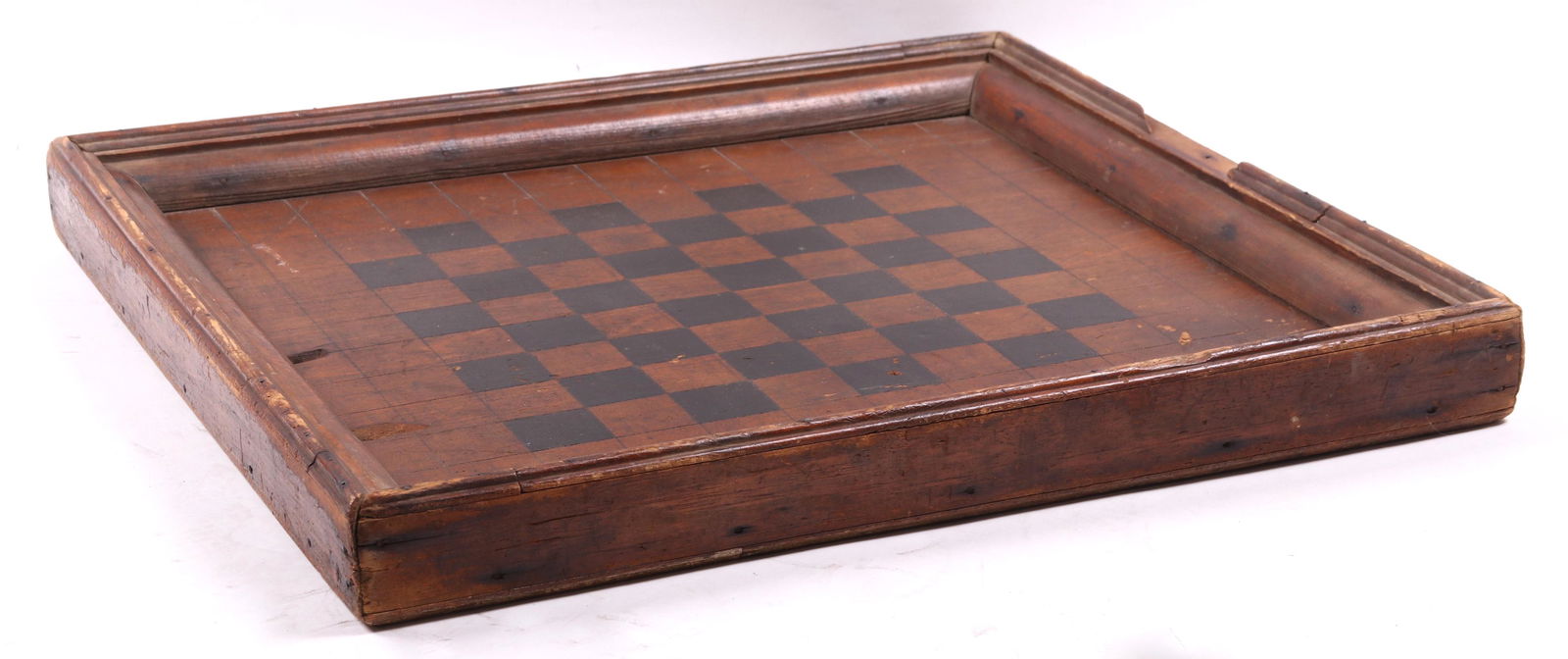 A Late 19th Century Parcheesi Board: A framed wooden board with incised lines and black paint. Checkerboard verso. Dimensions: 20 1/2" x 20 1/2", 2" thick.