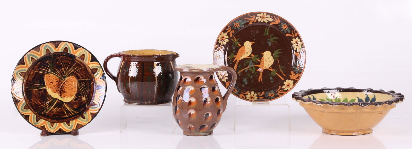 Five Pieces, Continental Redware: Two pitchers, two plates and bowl, various decoration including cat's eye and floral elements. Both plates are signed "St. Laurent". Dimensions: From 4 1/2" to 10 1/4" in diameter, the heights range f