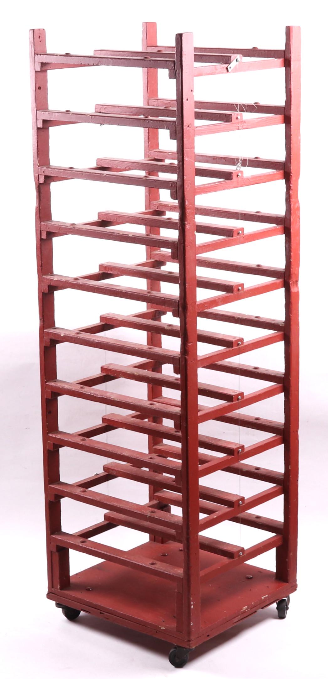 A Red Painted Wine Rack: 20th century, on casters. Dimensions: 18" x 19", 60" tall. Provenance: From a local collection.