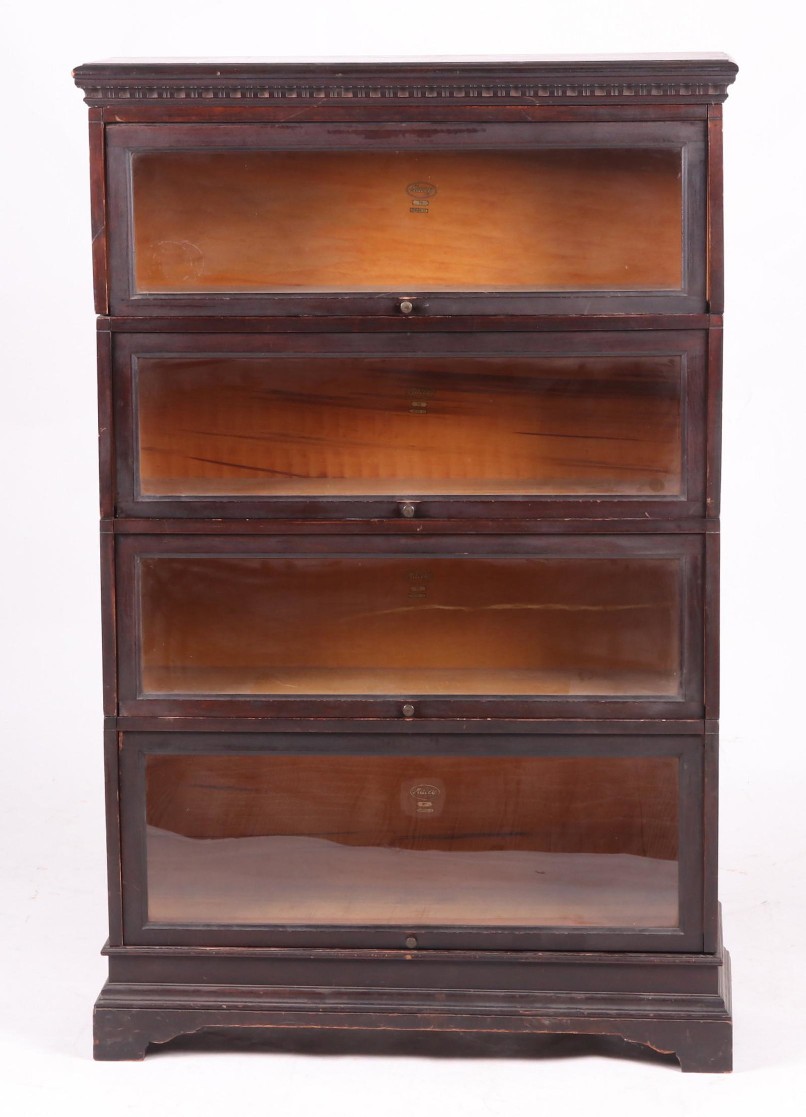 A Mahogany Barrister Bookcase by Macey: In four parts and with base and cornice. Dimensions: Each unit is 34 1/2" x 11 1/2" x 11 1/2", when assembled the measurements are 35 1/2" x 12 1/4" and 56" tall.