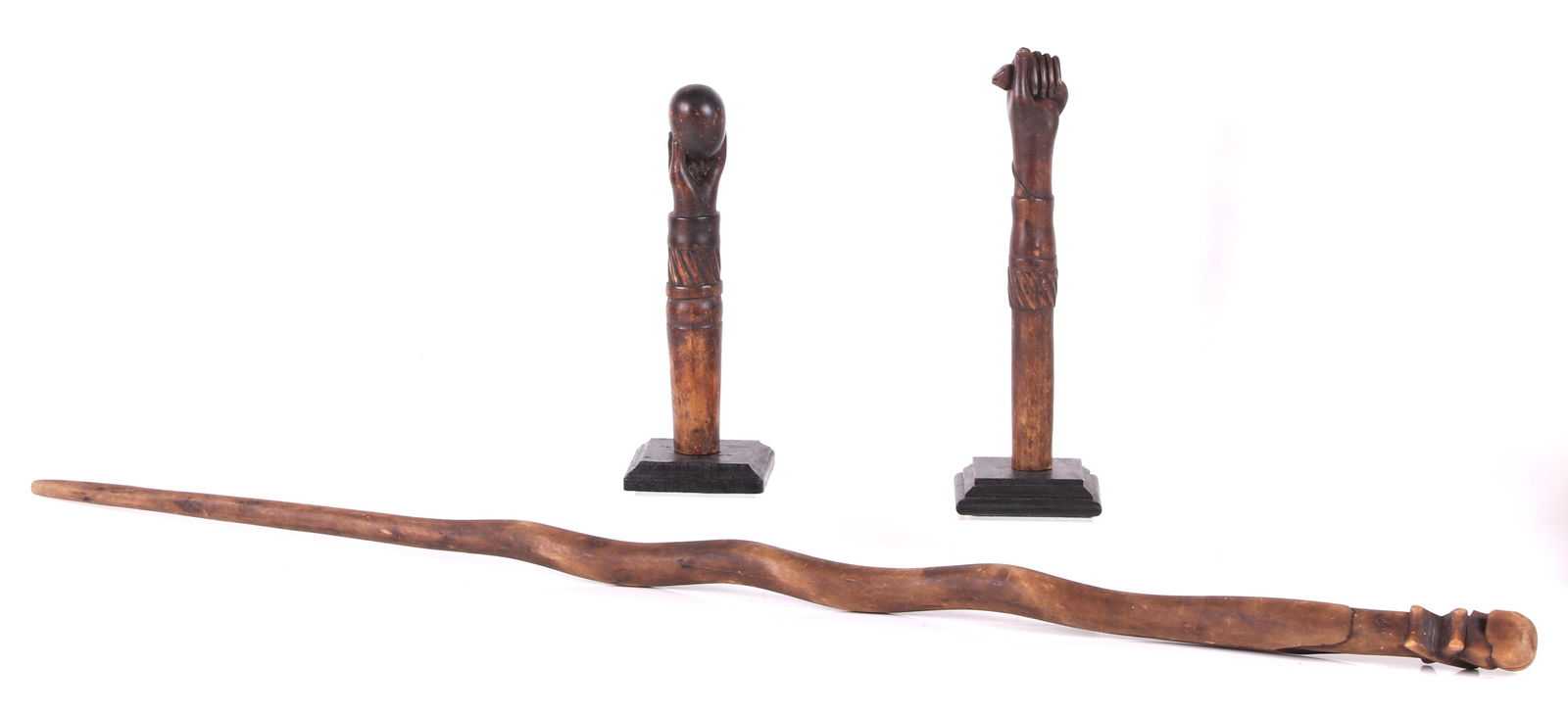 Three Folk Art Walking sticks: All American, a snake form example with skull and bones terminal and two arm and hand terminals, one hand holding an egg, the other a snake (walking sticks cut short), each mounted on a black painted