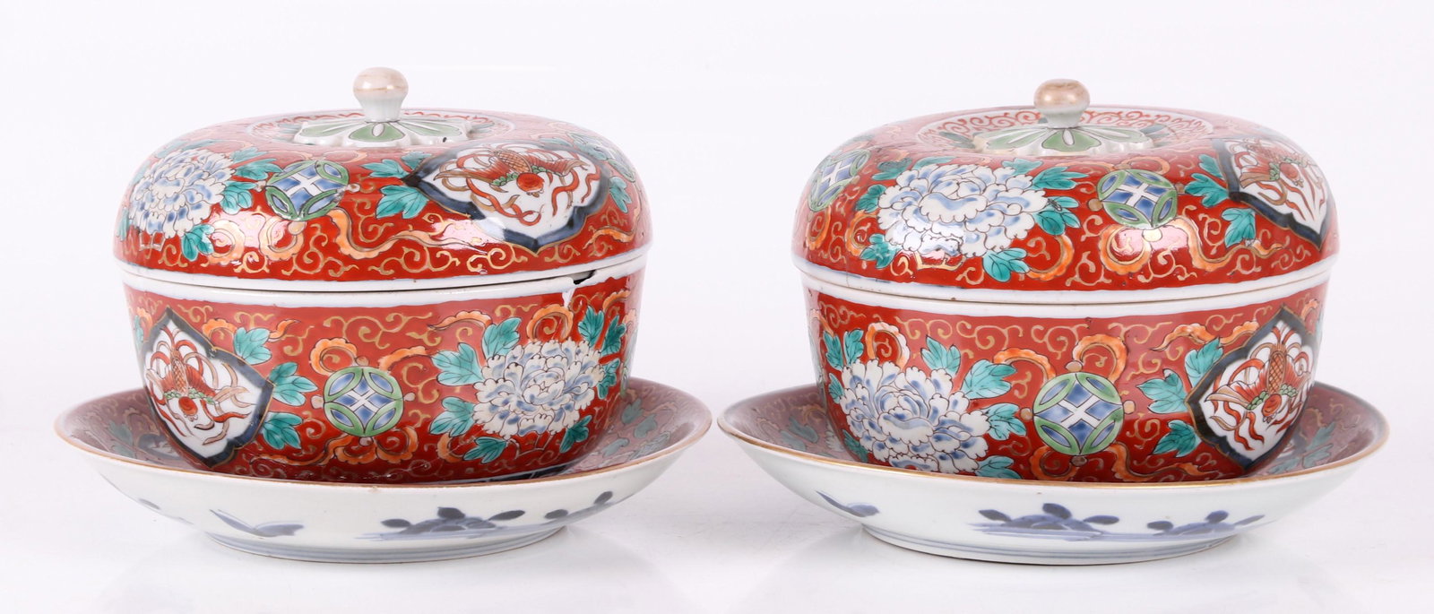 Pair of Imari Covered servers: Japanese, Meiji period. Each with a red ground and floral decoration. Dimensions: Each stand is 9" in diameter, and each body is 7 1/2" in diameter and 6" tall. Provenance: From a Philadephia collecti