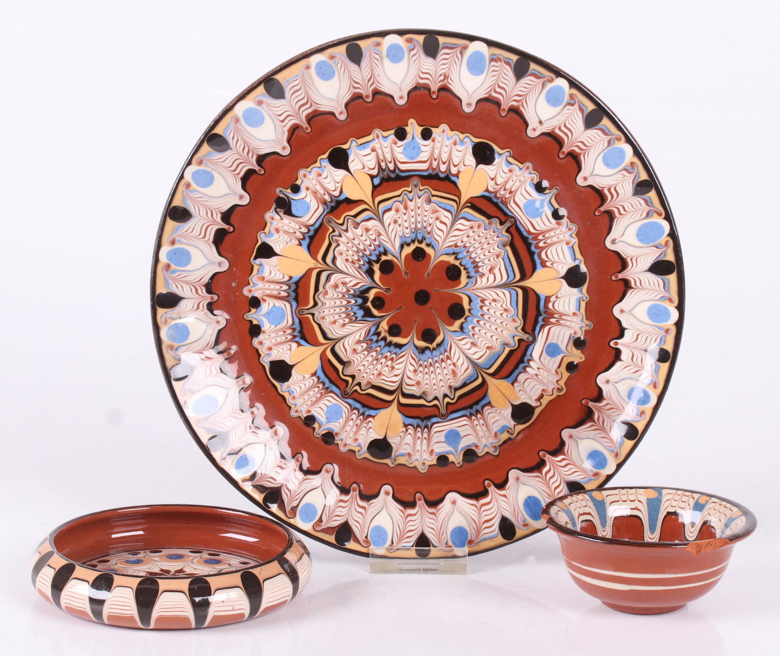 Three Pieces of Bulgarian Redware: A plate and two small bowls, all unsigned. Dimensions: From 3 1/2" to 8 1/2" in diameter, the heights range from 1" to 1 1/2".