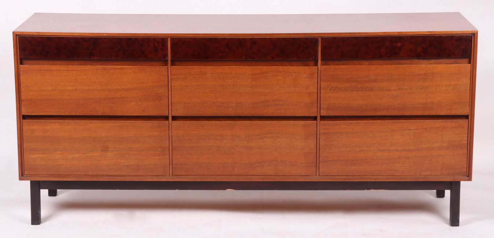 John Stuart for Mt. Airy Furniture, Low Dresser: Mid 20th century, walnut veneer, with square ebonized legs and three rows of three drawers, the uppermost with burled veneer. Marked 1364 at the back. Dimensions: 19" x 72", 32 1/2" tall. Provenance: