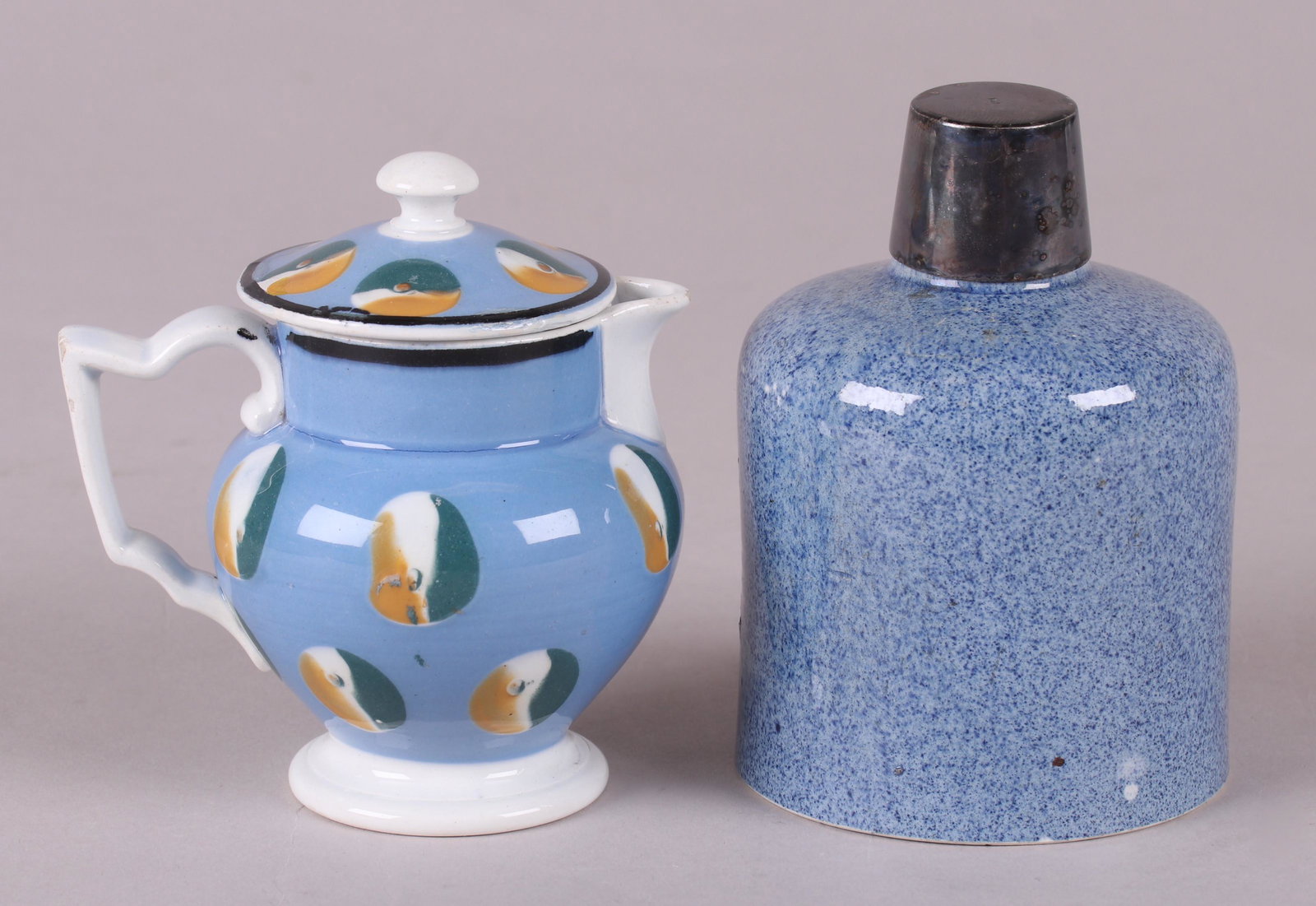 Two Pieces of Mochaware: A French covered cream jug with a pale blue ground and cat's eye decoration and a blue granite type pearlware English bottle with an associated silver plated cap. Dimensions: The bottle is 3" in diame