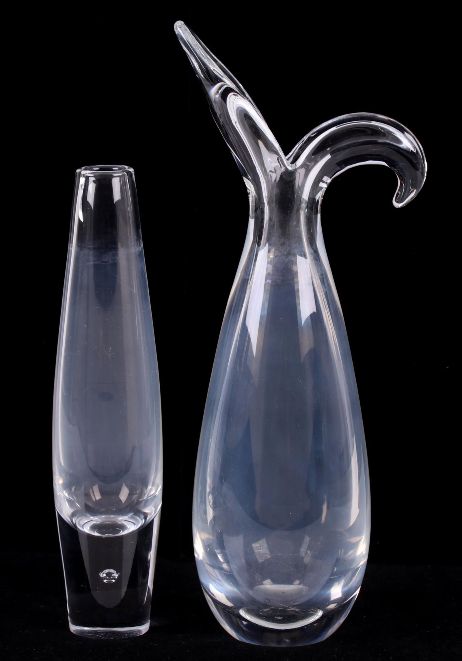 Two Steuben Glass Vases: A slender bud vase with trapped bubble decoration at the foot and a larger example with a bifurcated opening. Both signed. Dimensions: 2" and 3" in diameter, 8 1/4" and 11" tall. Provenance: From a lo