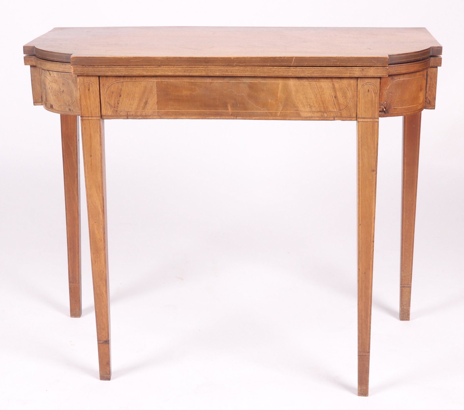 A Federal Period Mahogany Games Table: Philadelphia, mahogany, circa 1810, with square tapered legs, line inlay, a single hinged leaf and ovolo corners. Dimensions: 17" x 35 1/2", 29 1/2" tall. Provenance: From a Philadelphia estate.