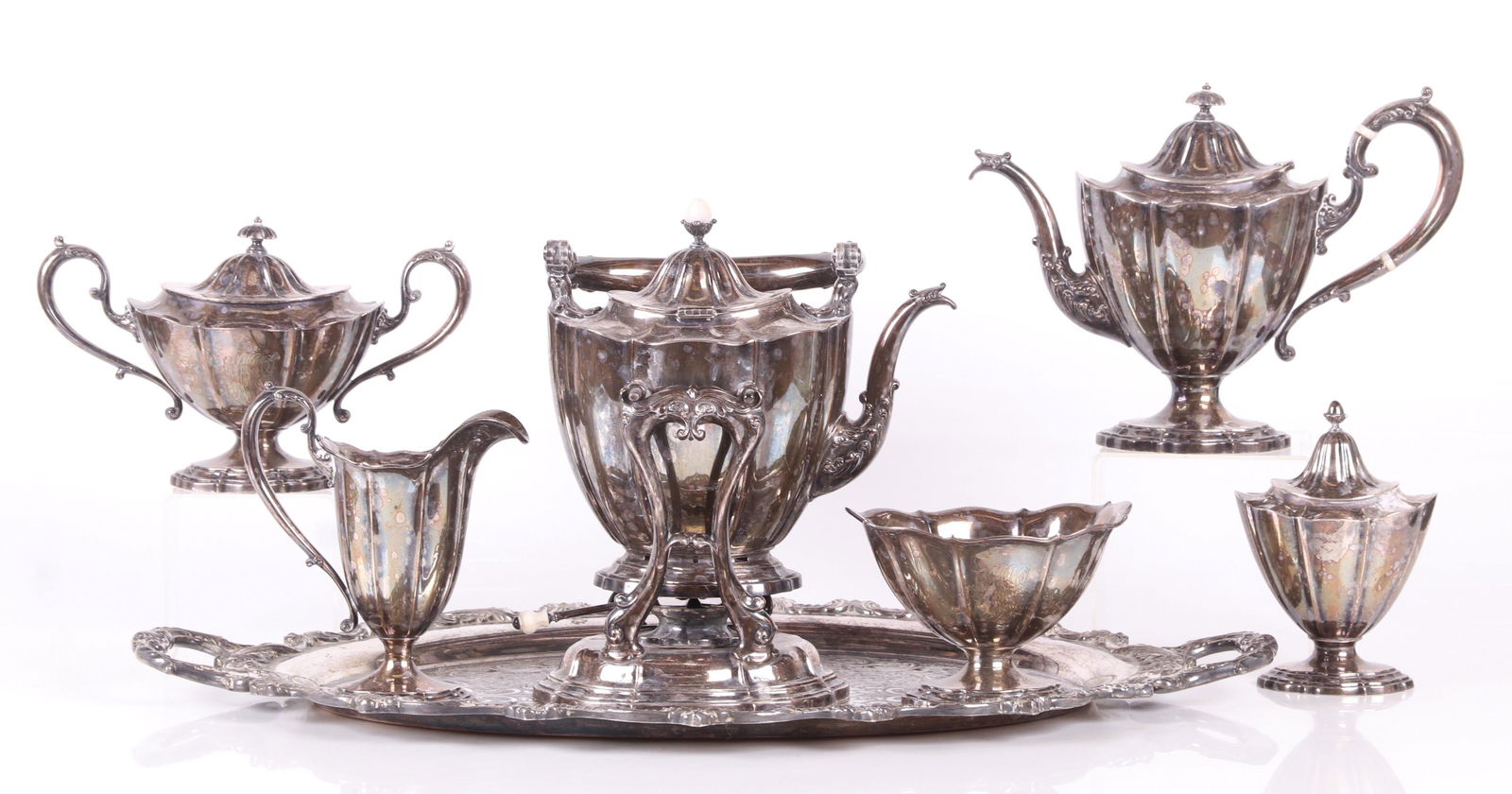 A Sterling Six Piece Tea Set J.E. Caldwell: A Georgian style six piece tea set marked for J.E. Caldwell and Durgin. The set consists of a kettle on stand, large covered sugar, small covered sugar, creamer, waste bowl and teapot. A silver plated