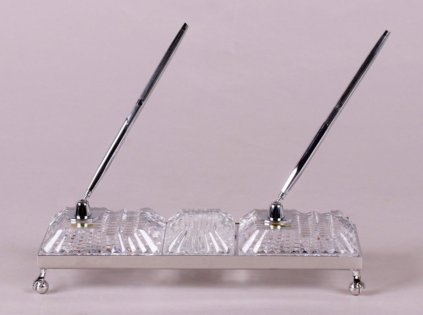 A Waterford Crystal Desk Set: With metal frame, two pen holders and paperweight, retains original box. Dimensions:10 1/2" x 4 1/2" and 2" tall. The box is 13" x 14" x 2 1/2". Provenance:From a local collection.