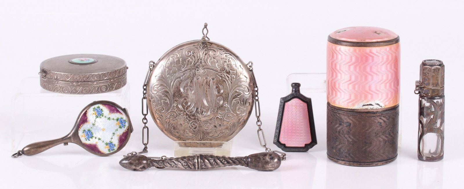 Estate Lot, Small Sterling Articles: All from the first half of the 20th century, comprising: a sterling needle case, an enamel decorated compact in the form of a hand mirror, a sterling overlay scent bottle, a sterling change purse with