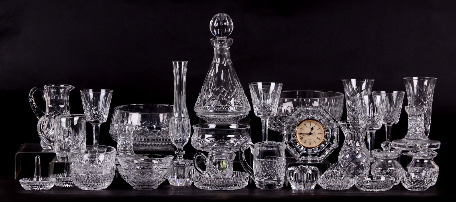 A Large Group of Waterford Crystal: All 20th century, various patterns, comprising: three creamers, a diamond form paperweight, two mustard jars, two ring holders, two pairs of candleholders, eight bowls of various sizes, a bud vase, a
