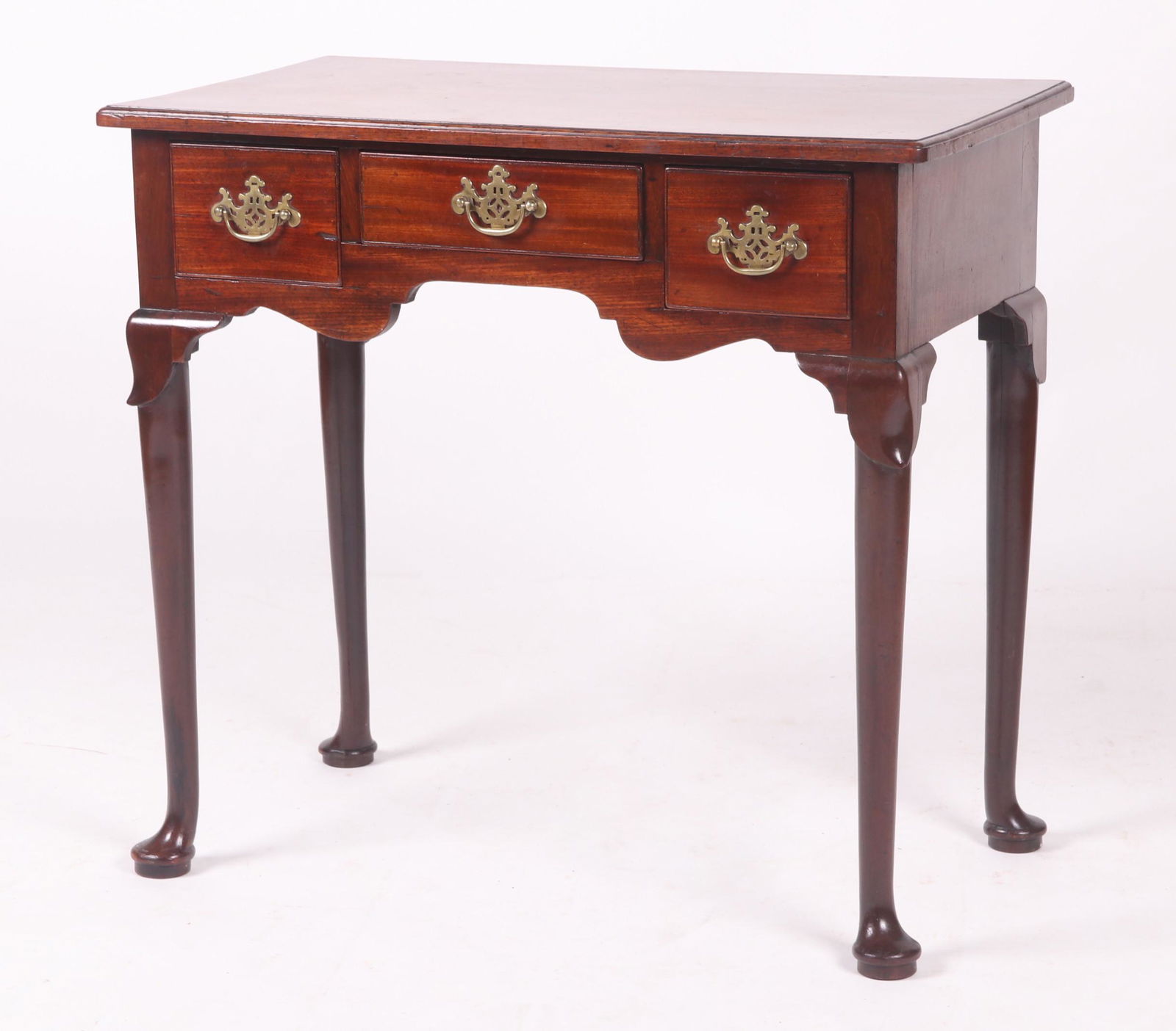 A Queen Anne Lowboy: English, 18th century, mahogany. With pad feet, three dovetailed drawers and a molded rectangular top. Retains the original brass pulls. Dimensions:The top is 30" x 17 1/2", the height is 28". Provena