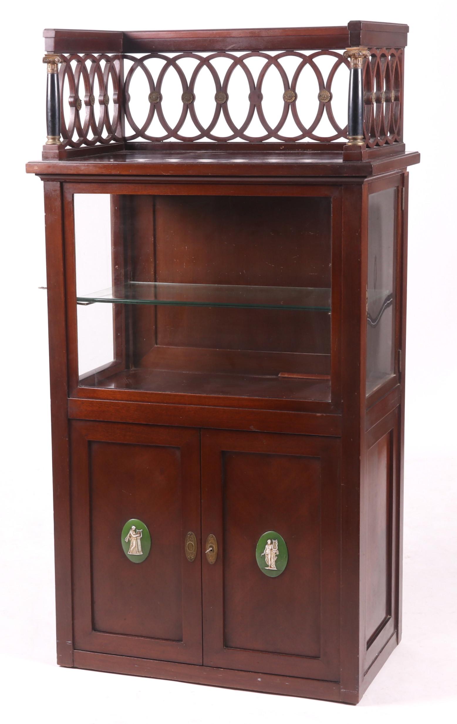 Mahogany Collector's Cabinet: From the first half of the 20th century, with two low door below a glass cabinet space that has doors at each side, all below a large ormolu mounted gallery. Dimensions:30" x 17", 56" tall. Provenance