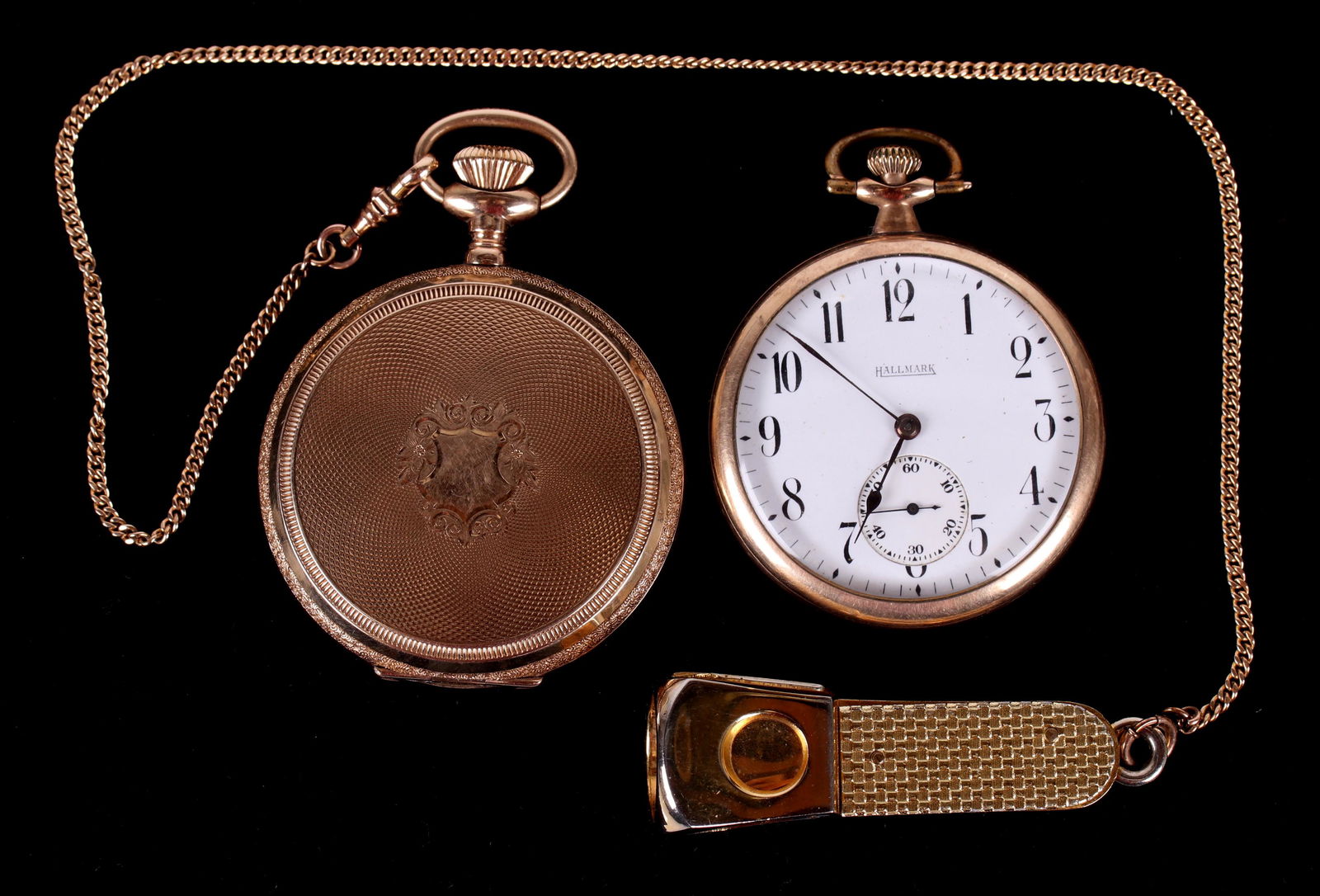 Two Pocket Watches: A gold filled Elgin with a hunter case, with plated chain and cigar cutter , and a gold filled watch marked for Hallmark which is open face. Dimensions:Both size 16. Provenance: