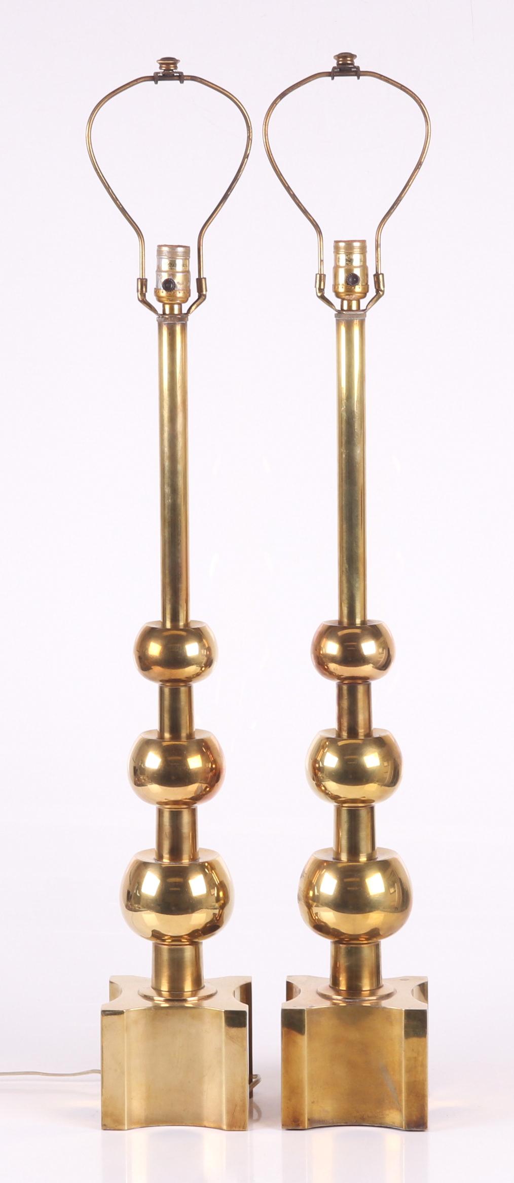 Manner of Tommi Parzinger Pair Stiffel Lamps: A pair of modernist lamps with square bases and tapered ball decorated shafts, each with Stiffel sticker at the socket. Dimensions: Each is 5 1/2" x 5 1/2" and 30 12" tall, not including the harps. Pr