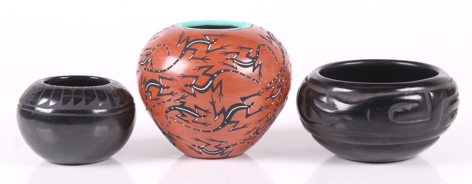 Three Pieces of Southwest Pottery: A small black bowl signed for Alfred Aguilar, San Ildefonso Pueblo, a carved bowl signed for Celes and Evelyn Aguilar of the Santa Clara Pueblo, and a painted vase decorated with repeated lizards sign