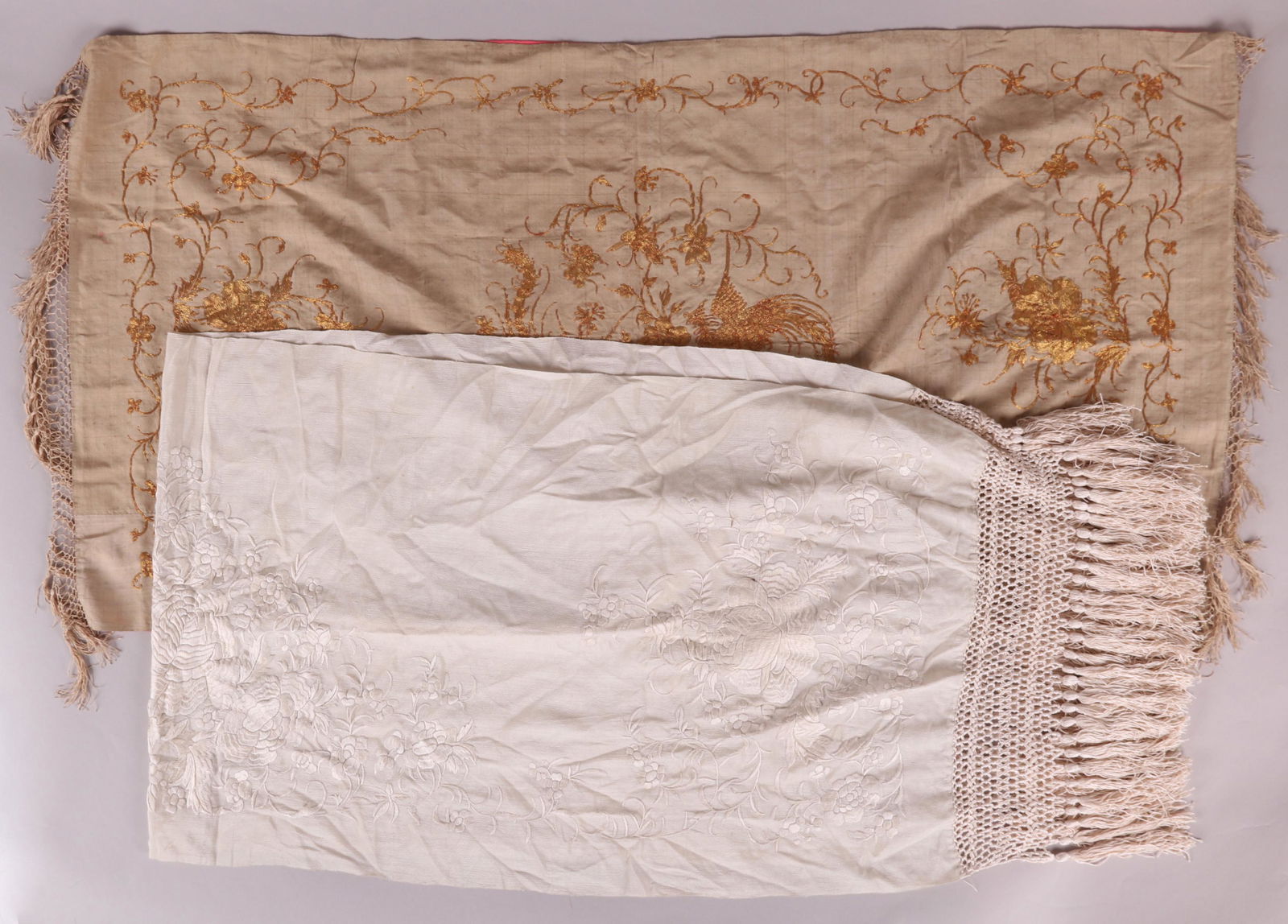 Two Chinese Silk Table Runners, 19th Century: An all white example with fringe at either side and embroidered floral decoration and a smaller example with phoenix and floral decoration in gold thread. Dimensions: 42" x 22" and 58" x 18", the dime