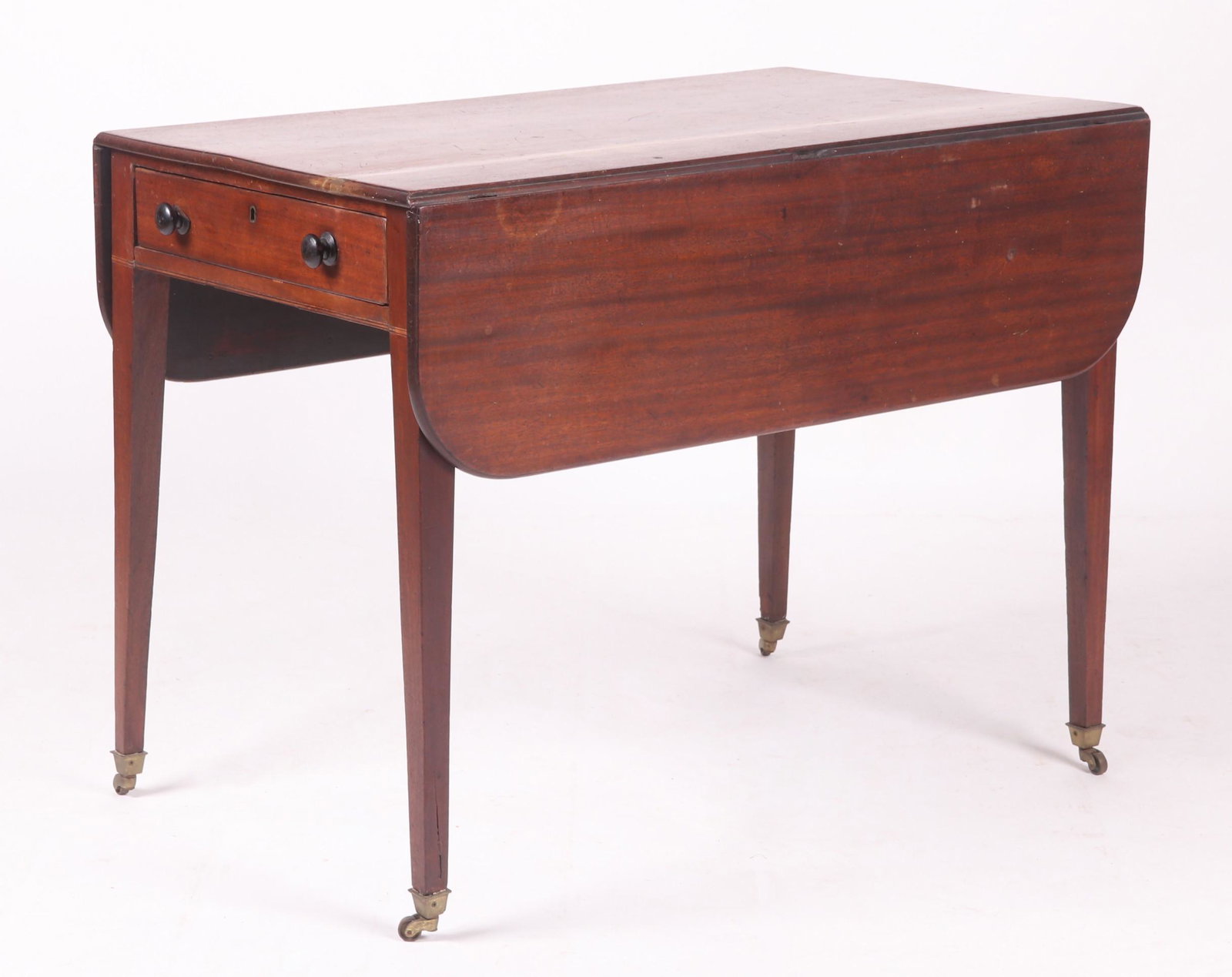 An English Drop Leaf Table: A Hepplewhite example circa 1820. With brass casters, square tapered legs, line inlay, one dovetailed drawer, a faux drawer at the opposite side and hinged leaves with rounded corners. Dimensions: 41"
