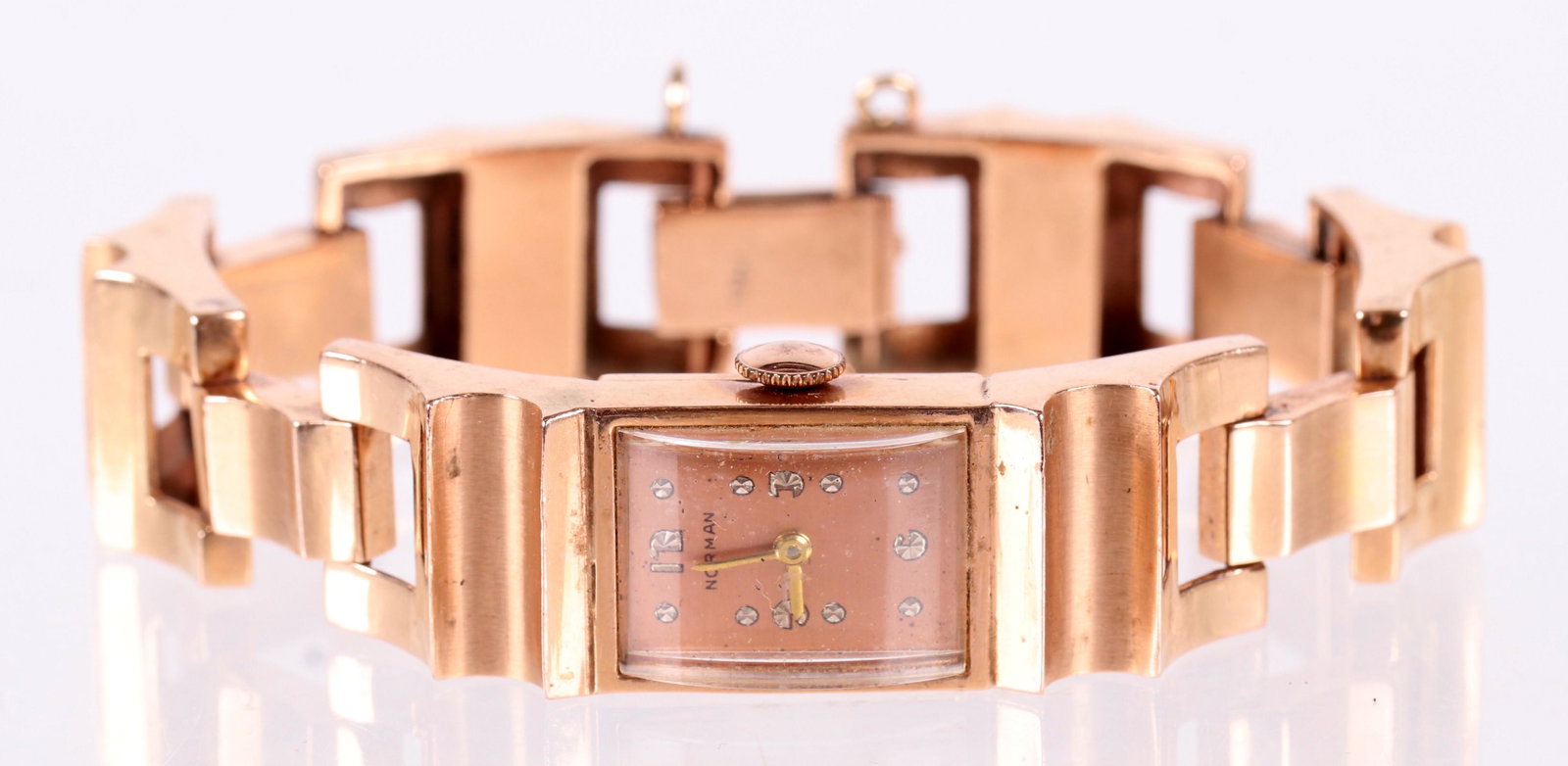 A Mid Century 14k Rose Gold Ladies Watch: The dial marked for Norman, the 14k rose gold bracelet has curved and chunky links. Dimensions: The total approximate weight is 30.3. dwt. The length is 7". Provenance: From a local collection.