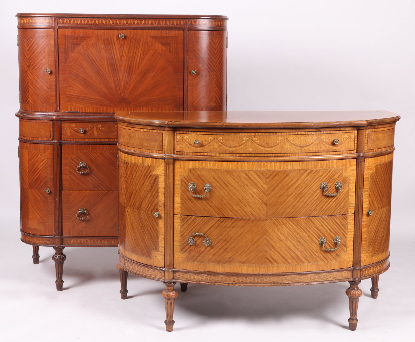 Two Pieces of Louis XVI Style Furniture: Both circa 1930 and having well figured veneer, short fluted legs and inlaid swag decoration. The commode features two central drawers flanked by side cabinets below a short upper drawer. The cabinet