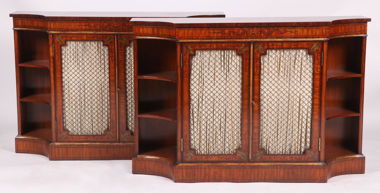 A Pair of Credenzas: Modern, each rectangular with arched front corners and features paneled and screened doors flanked by open shelves, all below the conforming top that features rosewood crossbanding and a painted flora