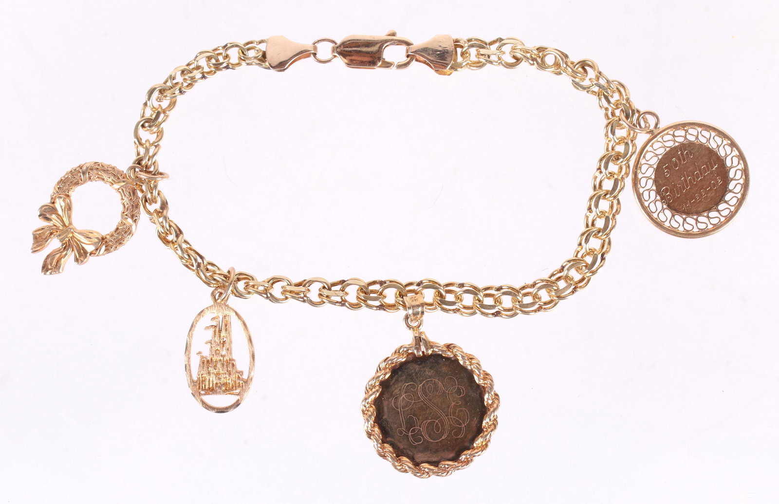 A14k Gold Charm Bracelet: Modern, with four charms. Dimensions: 7 1/2" long. The approximate weight is 12.9 dwt.