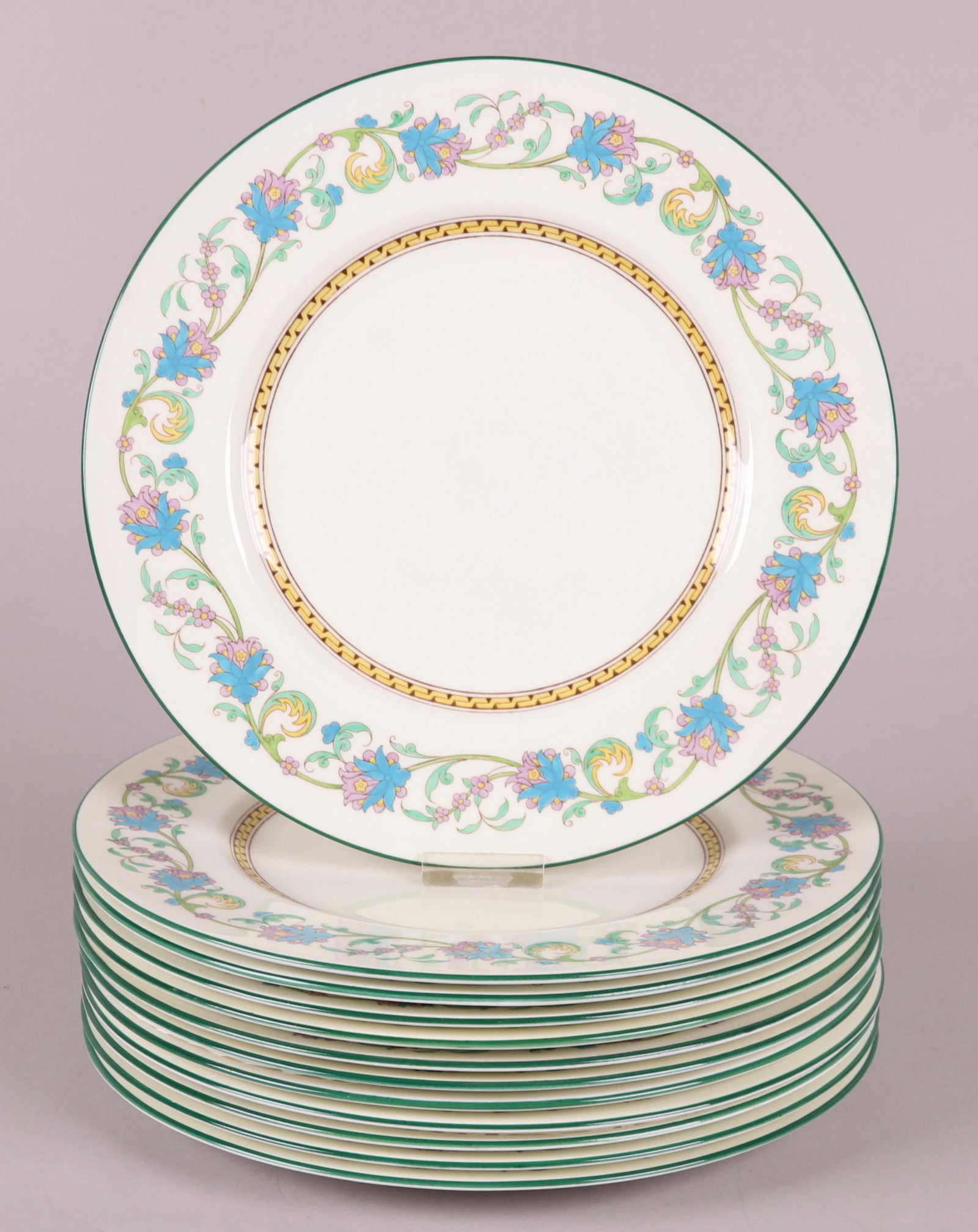 A Set of Wedgwood Dinner Plates, Shah Pattern: A set of twelve, each with green piping and enameled floral decoration. Dimensions: Each has a diameter of 10 3/4".