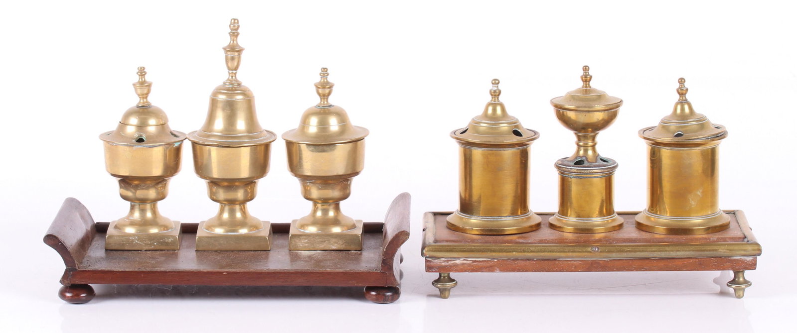 Two English Standishes, Brass and Wood: Both early 19th century and with three brass elements. Dimensions: 9 1/2" x 5" and 5" x 10:, the heights are 6 1/2" and 8 1/2".