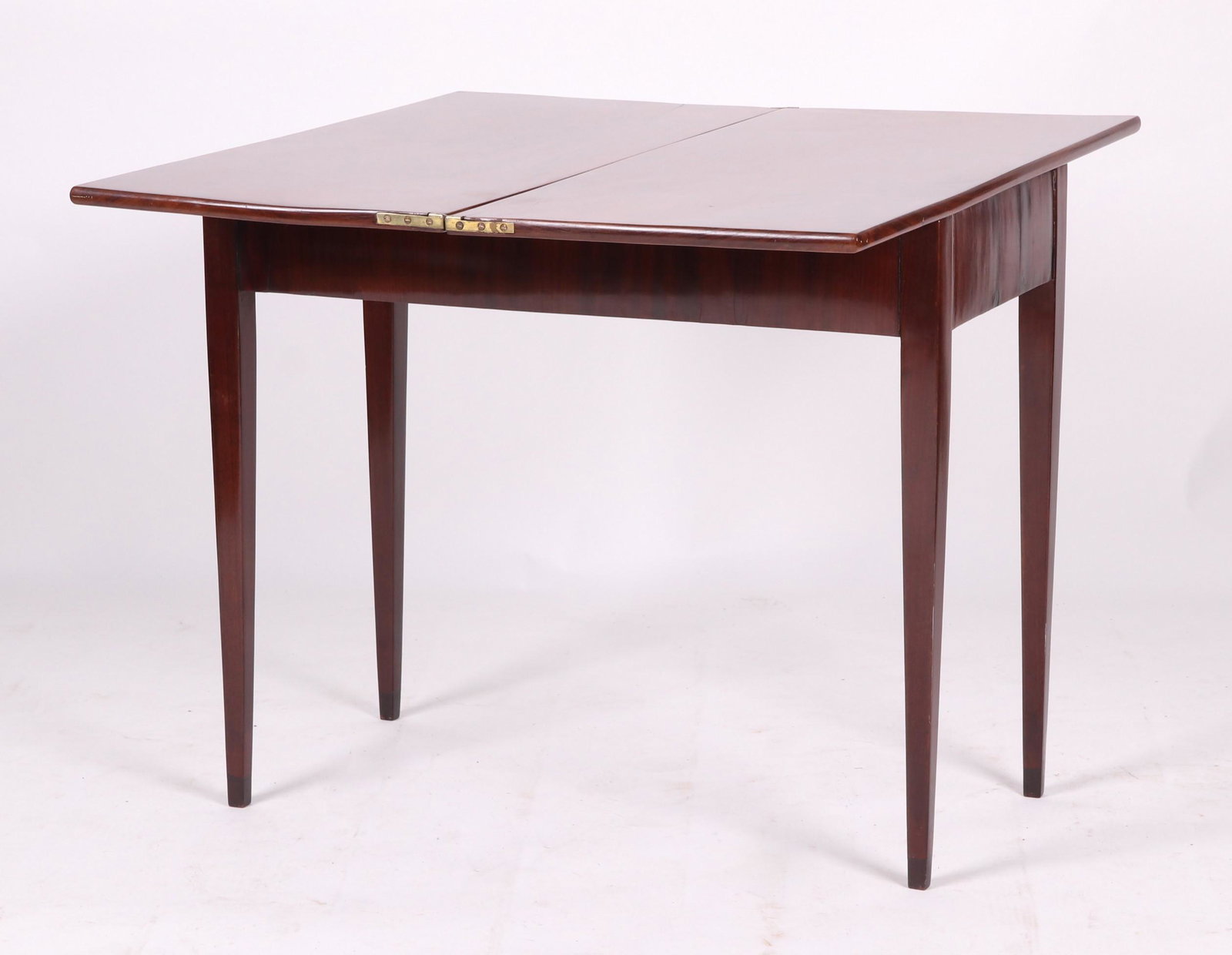 A Mahogany Hepplewhite Card Table: English, early 19th century, with square tapered legs and a top that rotates in order to support a single hinged leaf. Dimensions: 16 1/2" x 34" (closed) and 29" tall. Provenance: From a Philadelphia
