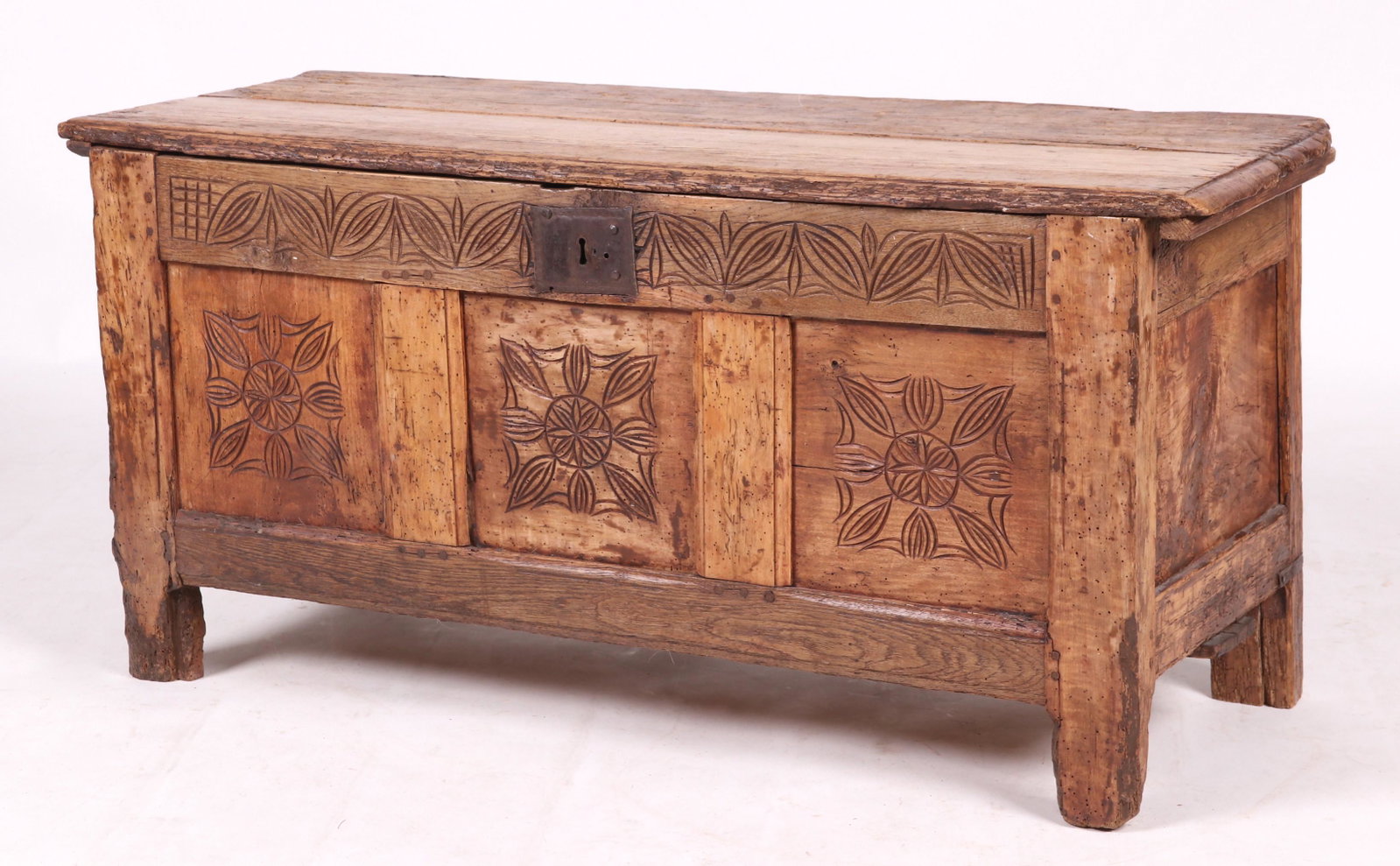 An 18th Century English Blanket Chest: Oak and pine with straight feet, paneled and pinned construction, foliate carving at the front and a lid with cotter pin hinges. Dimensions: 16 1/2" x 43", the height is 20 1/2".