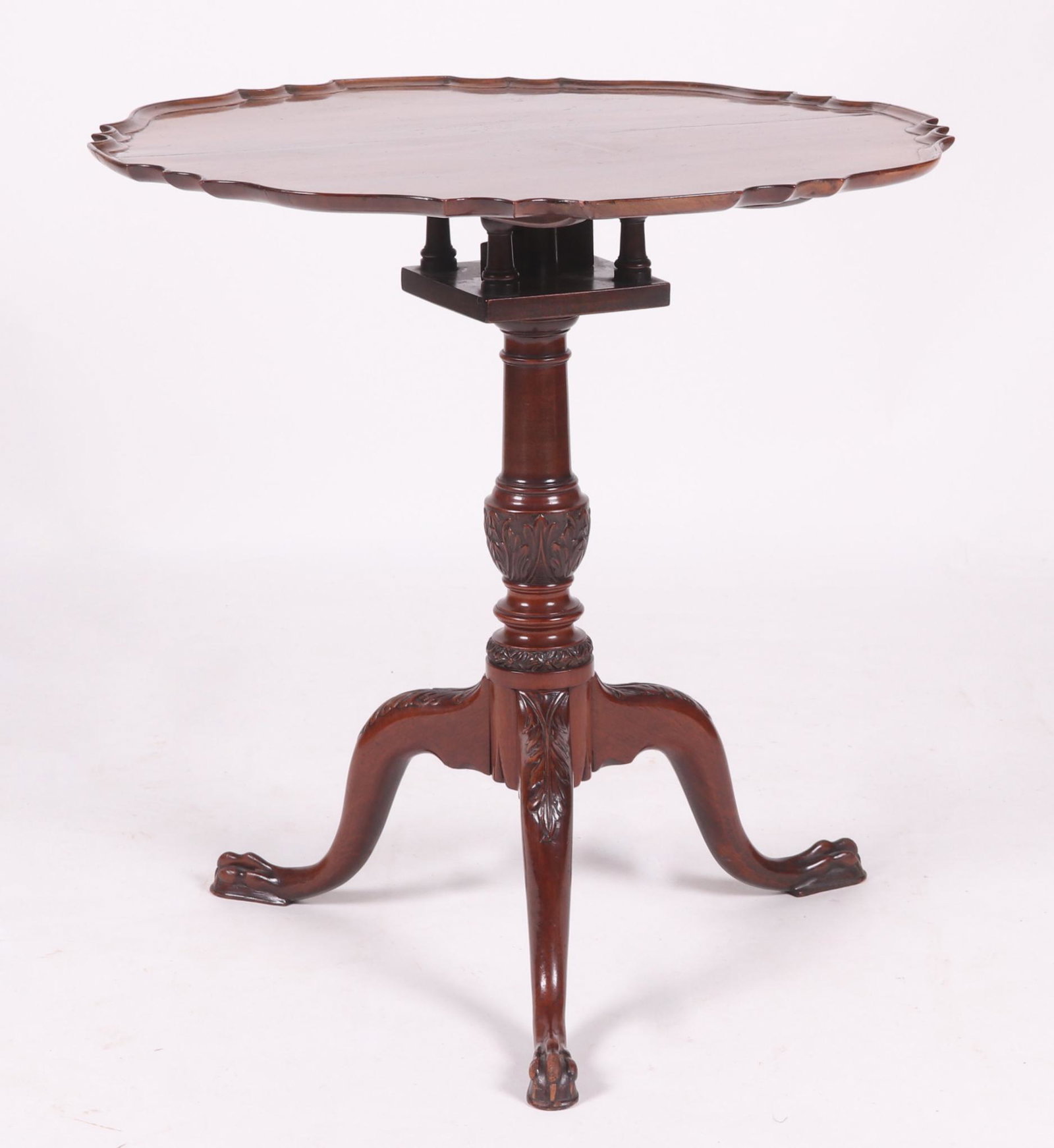 An English Pie Crust Mahogany Tea Table: 18th century. With paw feet, acanthus carved legs below an acanthus carved urn form shaft below the bird cage and dished pie crust top. The consignor used this piece as an end table. Dimensions: The t