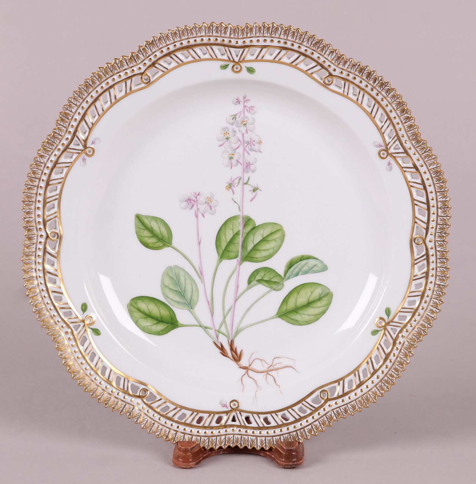 A Royal Copenhagen Flora Danica Plate: Hand painted, depicting Pyrola rotundifolia L. Marked as pictured. Dimensions: 11 1/4" in diameter. Provenance: From a Main Line Estate