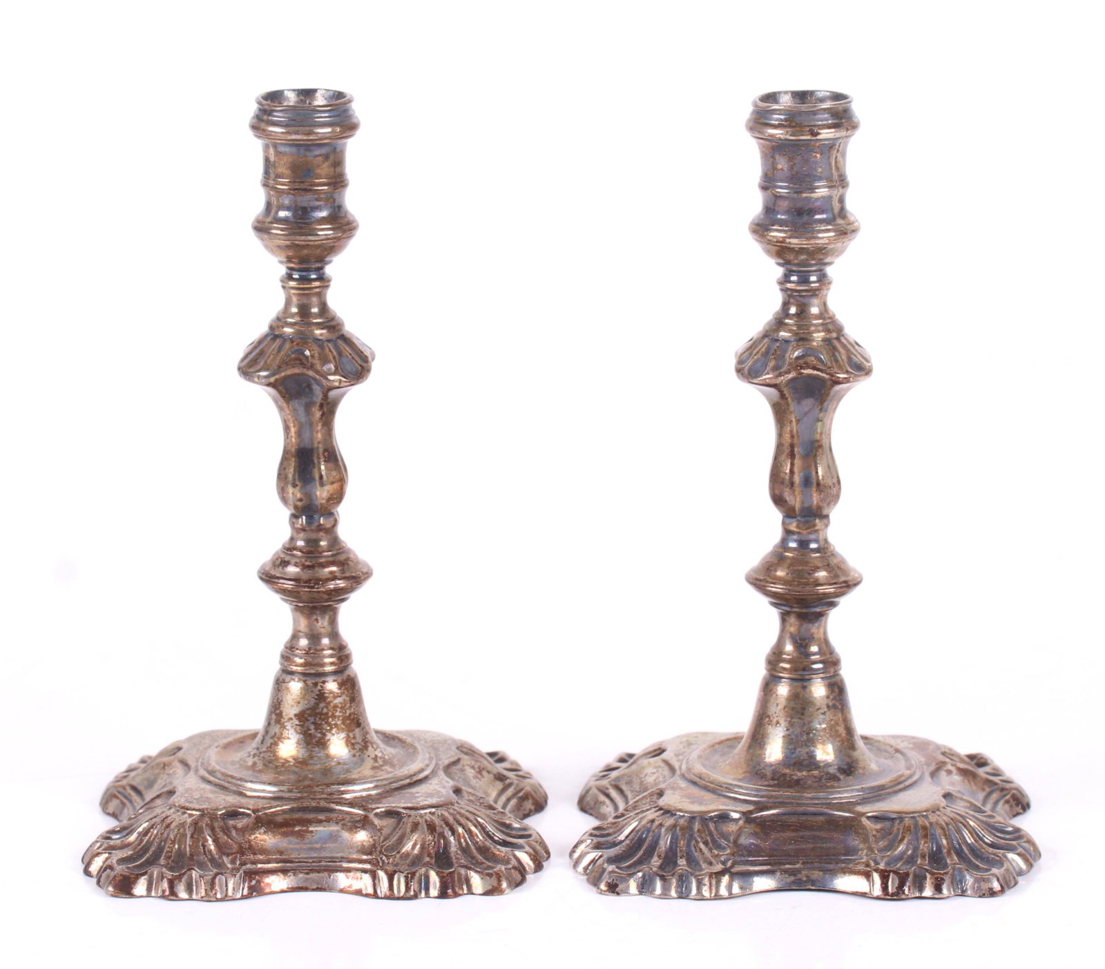 A Pair of English Sterling Tapersticks: Hallmarked for London, the year 1750-51 and the maker D:b. Each base with shell corners below a knobbed and baluster shaft and a ribbed nozzle. Dimensions: Each is 3" x 3" and 5" tall. The total appro
