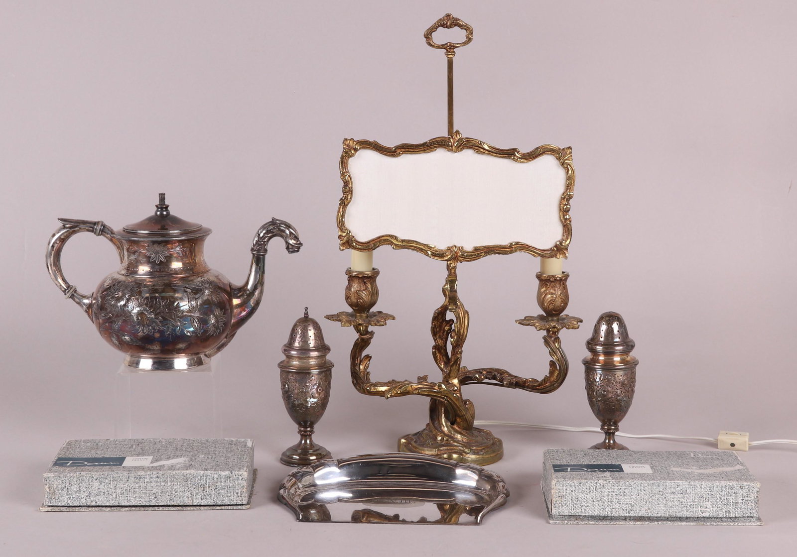 Estate Lot Including Tiffany: Comprising: A Tiffany and Co. silver soldered crumber, a Meriden silver plated teapot, a set of 12 boxed glass knife rests by Daum, a pair of silver plated repousse decorated castors, and a two light 