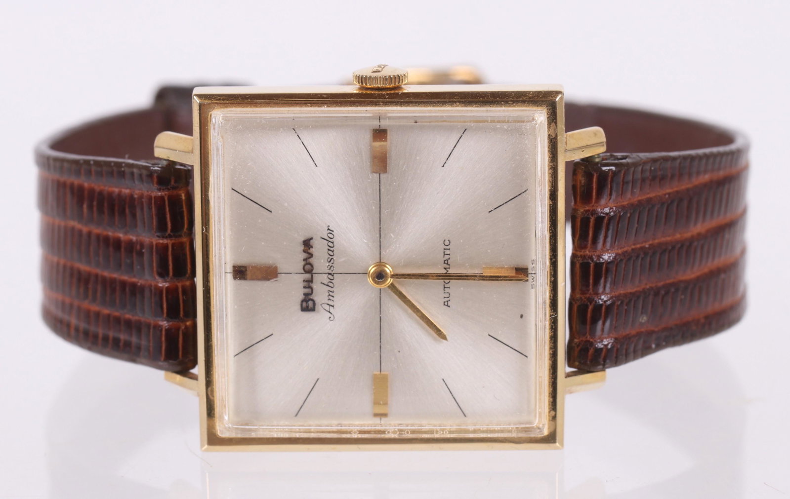 A Men's 18K Gold Watch by Bulova: An oversized watch with 18k gold case , 1 487225 M6, with leather band. Dimensions: 30mm. 38mm lug to lug. The total approximate gross weight including the band is 20 dwt. Provenance: From a local col