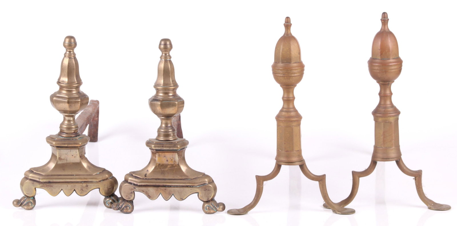 Two Pairs of Brass Andirons: A Pair of early 19th century Federal andirons with pad feet and acorn terminals and a pair of earlier andirons with scrolled feet and urn form terminals. Dimensions: The Federal examples are 9" x 17" 