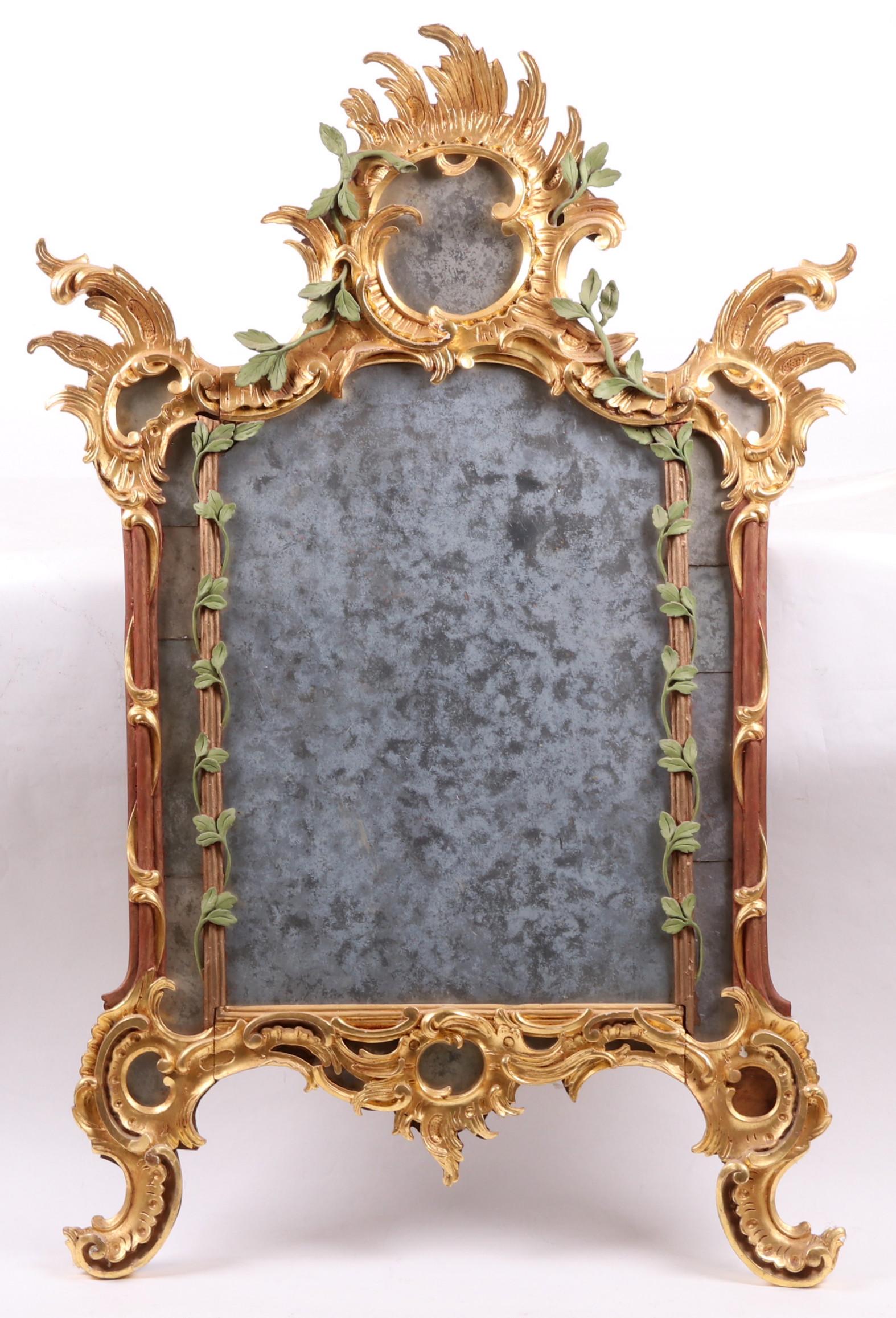 A Parcel Gilt Rococo Style Mirror: A modern mirror with green painted vines and a glass with an antiqued surface. Dimensions: 34" x 52".