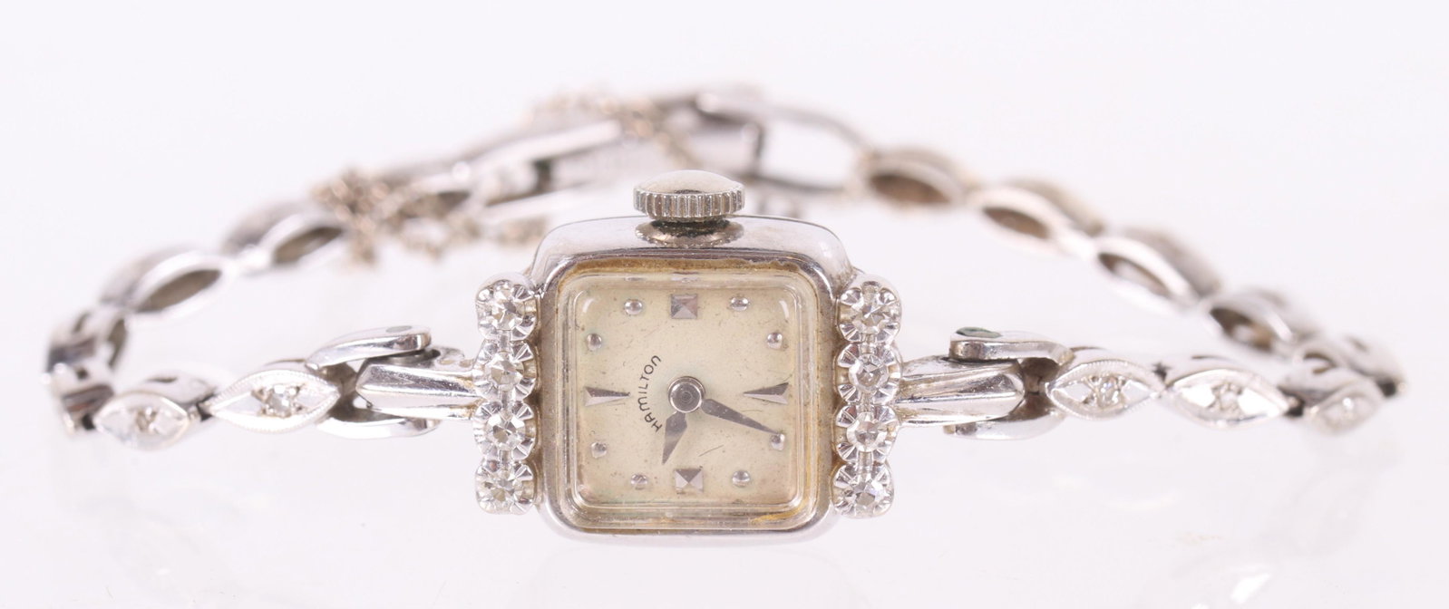 A Vintage Hamilton Ladies 14k Gold Watch: A mid 20th century ladies watch with a 14k white gold case set with eight small diamonds, 14k white gold band set with small diamonds and a 17 jewel movement. Dimensions: The case is 19mm x 15mm, the 